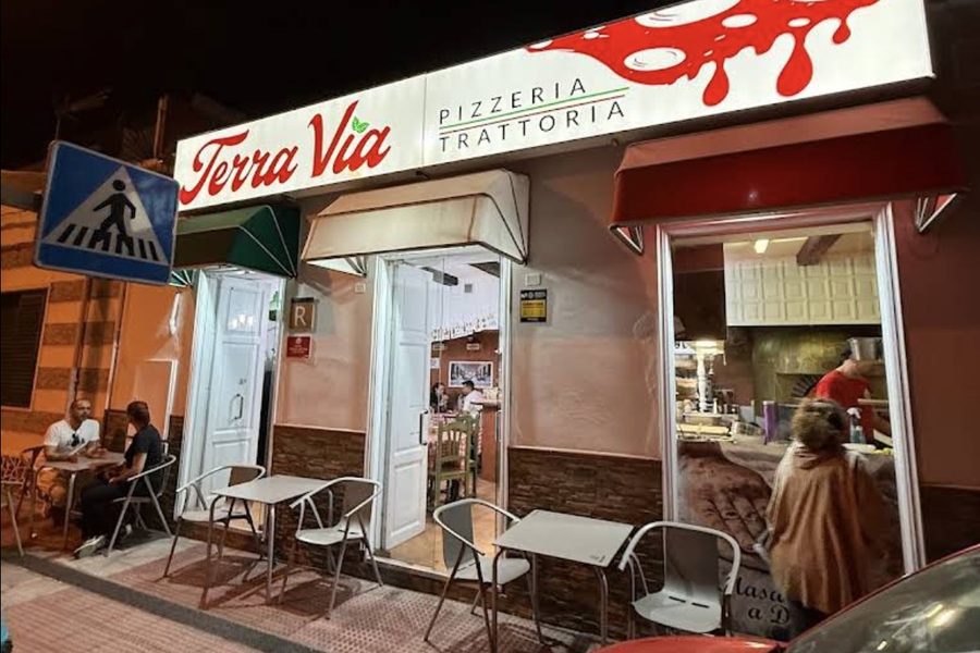 The Terra Via Pizzeria Trattoria storefront at night